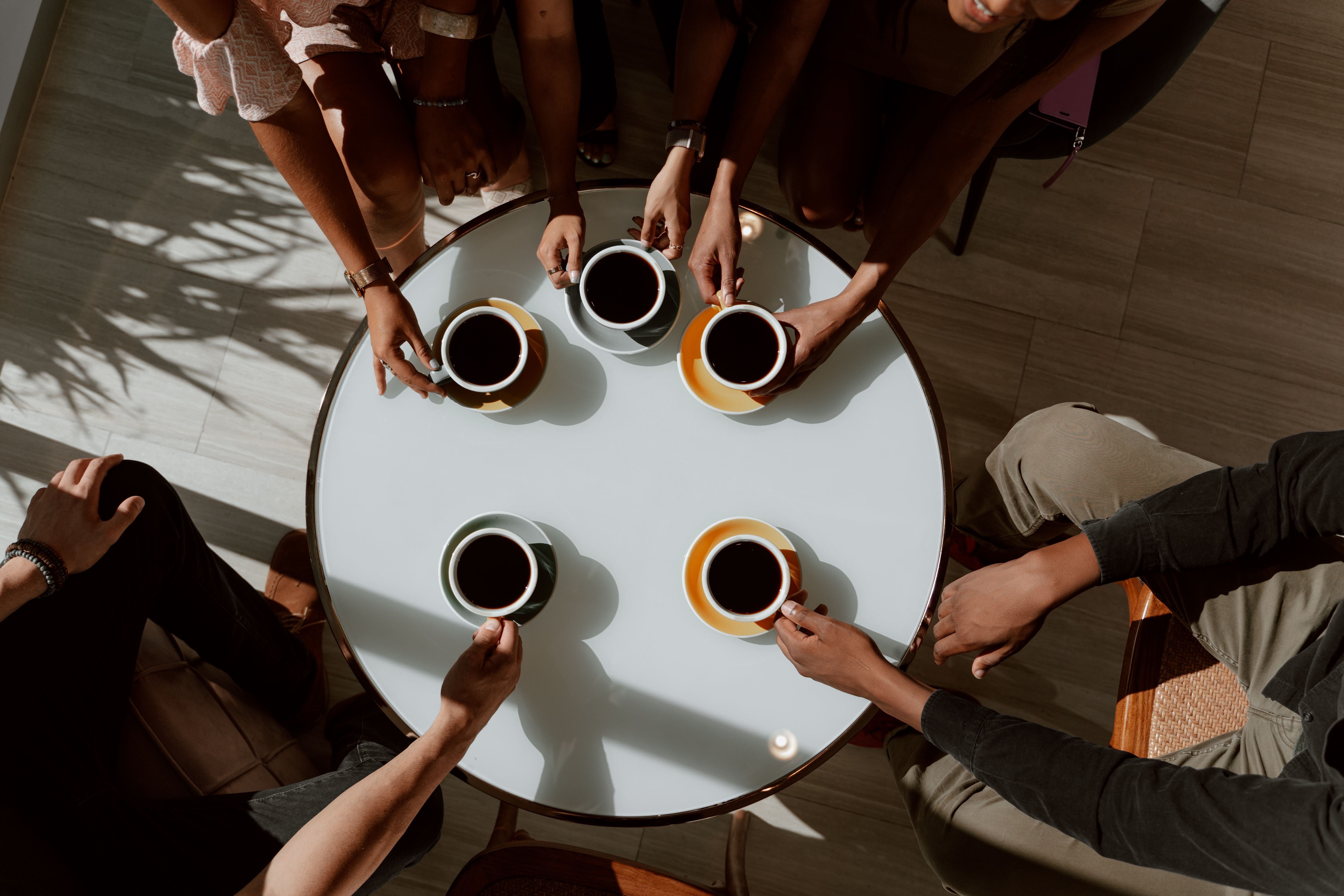 Friends gathered around a table sharing coffee